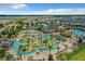 Aerial view showcases community lazy river and pool area with cabanas, slides, and lush landscaping for resort-style living at 4865 Clock Tower Dr, Kissimmee, FL 34746