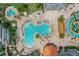 Aerial view of the community pool area featuring a large pool, splashpad, lounge chairs, and tropical landscaping at 4865 Clock Tower Dr, Kissimmee, FL 34746