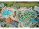 Aerial view of the community pool area featuring a large pool, splashpad, lounge chairs, and tropical landscaping at 4865 Clock Tower Dr, Kissimmee, FL 34746