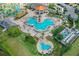 Aerial view features a Mickey Mouse-shaped community pool with lounge chairs, tropical landscaping, and an orange roof cabana at 4865 Clock Tower Dr, Kissimmee, FL 34746