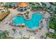 Aerial view features a Mickey Mouse-shaped community pool with lounge chairs, tropical landscaping, and an orange roof cabana at 4865 Clock Tower Dr, Kissimmee, FL 34746