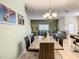 Elegant dining area featuring a long table, modern chandelier, and view into living room at 4865 Clock Tower Dr, Kissimmee, FL 34746