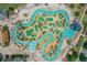 Aerial view of community lazy river and pool area with cabanas, slides, and lush landscaping for resort-style living at 4865 Clock Tower Dr, Kissimmee, FL 34746