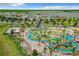 Aerial view of community lazy river and pool area with cabanas, slides, and lush landscaping for resort-style living at 4865 Clock Tower Dr, Kissimmee, FL 34746