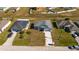 Overhead shot of a home with a two-car garage, neighboring houses, and green lawns at 613 James Ct, Poinciana, FL 34759