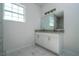 This bathroom features a double vanity with granite countertops and marble-look tile at 613 James Ct, Poinciana, FL 34759