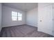 Carpeted bedroom features a window for natural light and a white door at 613 James Ct, Poinciana, FL 34759