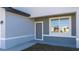 A tidy home entrance features a gray front door, clean stucco, and an exterior light fixture at 613 James Ct, Poinciana, FL 34759