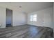 Bright living room features wood-look flooring, a large window, and a white front door at 613 James Ct, Poinciana, FL 34759