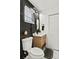 Contemporary bathroom with a wood vanity, modern mirror, and black accents at 7416 Kadel Way, Orlando, FL 32822