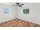 Bright bedroom featuring hardwood floors, two windows, and a ceiling fan at 7416 Kadel Way, Orlando, FL 32822