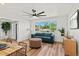 Bright living room featuring a comfortable blue sofa, modern decor, and a large window at 7416 Kadel Way, Orlando, FL 32822