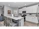 Modern kitchen with white cabinetry, stainless steel appliances, granite countertops, and bar seating at 7651 Sw 74Th Loop, Ocala, FL 34481