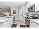 Bright kitchen features white cabinets, stainless steel appliances, quartz countertops, and wood-look tile floors at 7651 Sw 74Th Loop, Ocala, FL 34481