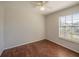 Bedroom featuring wood floors, a ceiling fan with light, and a large window at 7861 Copperfield Ct, Orlando, FL 32825