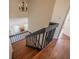 Interior view of staircase in home with wood steps, black railing, and a glimpse of the living room below at 7861 Copperfield Ct, Orlando, FL 32825