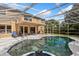 Back of house exterior featuring a sparkling screened-in pool and well-manicured backyard at 8606 Terrace Pines Ct, Orlando, FL 32836