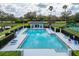 Large community pool with lounge chairs and tables for relaxation and recreation at 8606 Terrace Pines Ct, Orlando, FL 32836