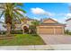 Charming tan two-story home with a three-car garage, lush lawn, and mature landscaping at 8606 Terrace Pines Ct, Orlando, FL 32836