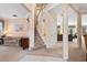 Bright foyer with staircase features neutral paint and carpet, wood railing, and high ceilings at 8606 Terrace Pines Ct, Orlando, FL 32836