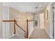 Hallway with white stair rails, tan carpet, and pendant lighting, leading to rooms at 8606 Terrace Pines Ct, Orlando, FL 32836