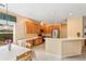 Bright kitchen and dining area with wooden cabinets, stainless appliances, tile floors, and sunlit windows dressed with green accents at 8606 Terrace Pines Ct, Orlando, FL 32836