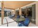 Relaxing covered patio with glass table and blue patio seating next to sliding glass doors at 8606 Terrace Pines Ct, Orlando, FL 32836