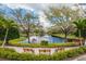 Community pond featuring walking path, bench seating, landscaping, and fountain at 8606 Terrace Pines Ct, Orlando, FL 32836