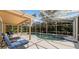 Enclosed private pool with a screened enclosure and sun loungers for relaxation at 8606 Terrace Pines Ct, Orlando, FL 32836