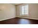 Empty bedroom with dark hardwood floors and a bright window at 8854 Oak Landings Ct, Orlando, FL 32836