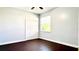 Cozy bedroom featuring dark wood floors, closet, and a sunlit window at 8854 Oak Landings Ct, Orlando, FL 32836