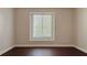 Empty bedroom featuring hardwood floors and natural light from the large window at 8854 Oak Landings Ct, Orlando, FL 32836