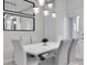 This is a lovely dining room with sleek white furniture, a bright aesthetic, and eye-catching modern lighting at 8907 Sydney Ave, Kissimmee, FL 34747