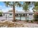 Fenced backyard with pool, palm trees, lush greenery and a covered patio for outdoor entertaining at 8908 Turnberry Ct, Orlando, FL 32819