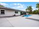 Spacious backyard featuring a pool with rock detail, a large patio area and manicured greenery at 8908 Turnberry Ct, Orlando, FL 32819