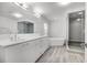 A modern bathroom with dual vanity, soaking tub, glass shower with tile accent wall and wood-look ceramic tile floors at 8908 Turnberry Ct, Orlando, FL 32819