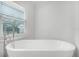 This bathroom has a free standing tub with faucet near a bright, sunny window at 8908 Turnberry Ct, Orlando, FL 32819