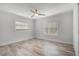 Light-filled bedroom features two windows, wood-look floors, base molding, and modern ceiling fan at 8908 Turnberry Ct, Orlando, FL 32819