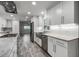 Well-lit kitchen featuring stainless steel appliances, marble countertops, white cabinetry, and wood-look tile flooring at 8908 Turnberry Ct, Orlando, FL 32819