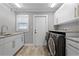 A well lit laundry room with stainless steel washer and dryer and granite countertops at 8908 Turnberry Ct, Orlando, FL 32819