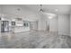 Open floorplan with wood-look tile flooring connects the living area to the modern kitchen with island at 8908 Turnberry Ct, Orlando, FL 32819