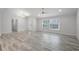 Spacious living room featuring wood-look tile flooring, natural light, and an open floor plan at 8908 Turnberry Ct, Orlando, FL 32819