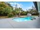 Backyard swimming pool with a rock detail, lush greenery, a fence and a storage shed at 8908 Turnberry Ct, Orlando, FL 32819