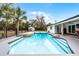 Backyard pool and patio with rock detail, surrounded by lush greenery, fenced-in, with an adjacent covered porch at 8908 Turnberry Ct, Orlando, FL 32819