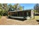 Exterior view of a single-story home featuring a large screened-in porch at 20144 Se 156Th St, Umatilla, FL 32784
