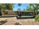 Side view of a single-story home featuring a large screened-in porch under a clear, blue sky at 20144 Se 156Th St, Umatilla, FL 32784