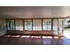 Bright sunroom with multiple windows, wood laminate flooring, and a white door at 20144 Se 156Th St, Umatilla, FL 32784