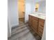 Bathroom vanity with wooden cabinets, gray floors and a view of the walk-in closet at 11618 Churchill St, Orlando, FL 32817