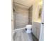 A modern bathroom featuring tiled shower, with a mosaic tiled accent wall and gray cabinets at 11618 Churchill St, Orlando, FL 32817