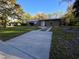 A single-story home featuring a well-maintained lawn and a long concrete driveway on a bright, sunny day at 11618 Churchill St, Orlando, FL 32817